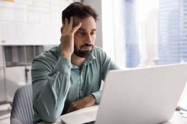 Sıkılmış Latin işadamı laptopun başına dokunuyor, problem, hata, hata, kötü haber, iş yerindeki bilgisayarı kullanıyor, sorunları düşünüyor, aşırı çalışıyor gibi hissediyor.
