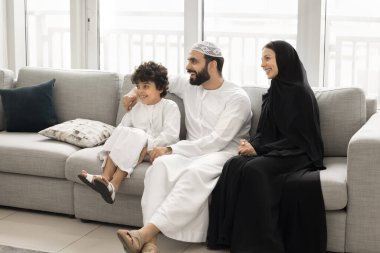 Geleneksel Müslüman kıyafetleri içinde Arap bir çift ve küçük oğlu oturma odasında kanepede oturur, gülümser, yan bakar, birlikte vakit geçirir ve modern dairede güzel bir hafta sonu geçirirler. Kültür, aile bağları