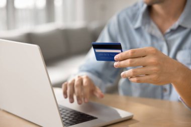 Kırpılmış manzarayı kapatan adam internet mağazası üzerinden dizüstü bilgisayar satın alma kartı tutuyor, aylık abonelik hizmetleri için ödeme yapıyor, otel rezervasyonu yapıyor, hediyeler alıyor, anlık e-servis web sitesi kullanarak para transfer ediyor.