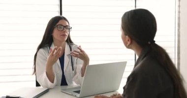 Dost canlısı ve bilgilendirici bir konuşma yapan, özel kliniğe yaptığı ziyarette kadın hastalara teşhis veya tedavi planını açıklayan, kaliteli sağlık hizmetleri sunan ceketli kadın doktor