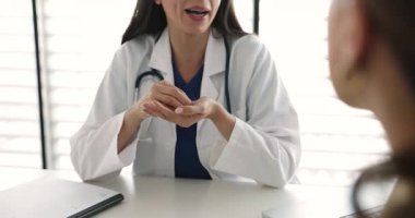 Masada oturan beyaz önlüklü kadın doktor kadın hastayla konuşuyor, ilaç talimatlarını ya da sağlık tavsiyelerini, ameliyat detaylarını ya da riskleri açıkla, kapat. İlaç.
