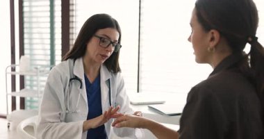 Doktor hastanın elini muayene eder, bağların aşırı gerilmesi ya da yırtılması semptomlarını tartışır, kırık ya da yaralanma nedeniyle rehabilitasyona danışmanlık sırasında profesyonel değerlendirme yapar.