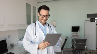 İş yerinde tablet kullanan bir terapist, uzaktan teletıp kullanan bir klinik hastasına danışmanlık, inceleme geçmişi veya anestezi için elektronik sağlık kayıtlarına erişim, muayene laboratuvarı, röntgen veya MRI taramaları