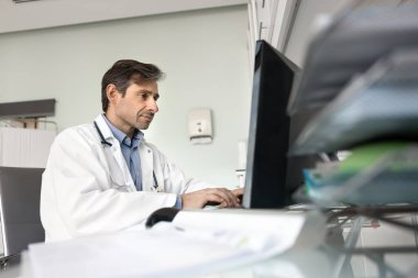 Doktor e-posta yazıyor, hastalık belirtileri veya tedavi planı konusunda meslektaşlarına danışıyor, randevuları ayarlıyor, hasta ziyaretlerini yönetiyor, bilgisayar başında oturan tıbbi test raporlarını analiz ediyor.