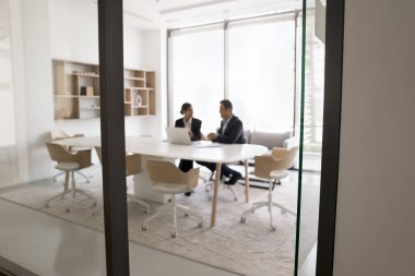 Modern dizüstü bilgisayarla ortak görev tamamlama üzerinde çalışan iki Hintli iş arkadaşı, çevrimiçi proje geliştirmeyi tartışıyor, yeni yaratıcı başlangıç fikirlerini paylaşıyor, toplantı odasında üretken bir takım çalışması yapıyor.