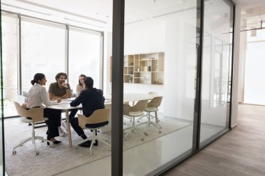 Çok ırklı iş ortakları, çalışanlar, hissedarlar kapalı kapılar ardında pazarlık yapıyor, konferans masasında oturuyor, işle ilgili meseleleri tartışıyor, fikir alışverişinde bulunuyor, çözümleri paylaşıyorlar. Takım çalışması.