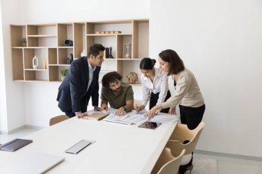 Dört şirket üyesi konferans masasının etrafında toplandı, ortak bir tartışma veya beyin fırtınası oturumu, inceleme belgeleri, not alma, strateji yapma, planlama veya karar verme işleriyle meşgul