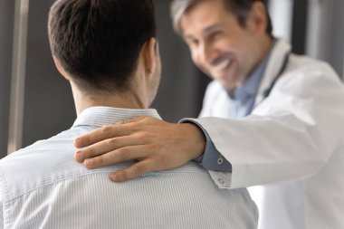 Doktorlar, güvence, cesaret ve fizyolojik desteğin sembolü olarak hastanın omzunu kapatırlar. GP tıbbi bakım sağlar, tavsiye verir, iyileşme ve tedavinin etkili sonuçları hakkında konuşur