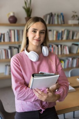 Çalışkan akademisyen. Sınıfta portre için poz veren gülümseyen kız kağıt çalışma kitapları seti kurslarının keyfini çıkarın. Modern üniversite üniversitesinde okumak için öğrenci kredisi bursu almaktan mutluluk duyarız.