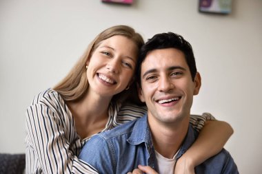 Güzel İspanyol evli çiftin yakın plan portresi. Kameraya bakıyorlar. Kanepede birlikte oturuyorlar. Romantik ilişkiler