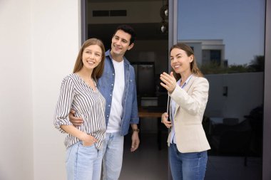 Gayrimenkul izleme, emlak yatırımı, ev sahibi olma arzusu. Emlakçı genç çifte ev turunda rehberlik ediyor, yeni bir ev ya da kiralık ev gösteriyor, tesisler ve konum güvencesi hakkında bilgi veriyor.