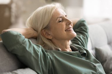 Duygusal denge ve iç huzur. Kaygısız yaşlı kadın emekliler koltuğa yaslanıyor. Kafalarının arkasında rahat pozlar veriyorlar. Gözler kapalı, nefes alıyor. Portreyi kapat