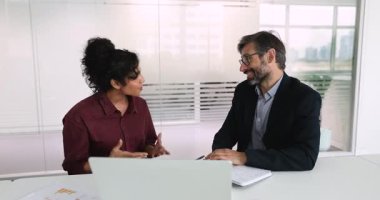 Gülümseyen Hintli iş kadını toplantı masasında oturan işadamıyla tokalaşıyor, ticari anlaşmayı kapıyor, ortaklığa başlıyor, başarılı bir iş görüşmesi veya pazarlığı bitiriyor. İş, görgü kuralları