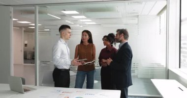 Çok uluslu genç ve orta yaşlı takım arkadaşları, takım tartışmasına katılan şirket çalışanları veya eğitimden sonra brifing veren veya modern konferans odasında resmi toplantı yapan şirket çalışanları. İş iletişimi