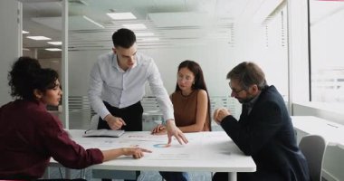 Proje pazarlama stratejisi üzerinde çalışan çok uluslu iş adamları, istatistik verilerini gözden geçirir, tabloya yayılmış tablo ve diyagramlarda sergilenen satış raporlarını analiz ederler. Planlama, işbirliği