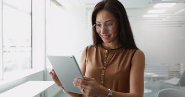 Yönetim kurulunda dijital tablet kullanan, iş e-postalarını kontrol eden, müşteri sorularına cevap veren, bildiri okuyan, işle ilgili konuları uzaktan çözen bir iş kadını. AI yenilikçi araçlar kullanımı