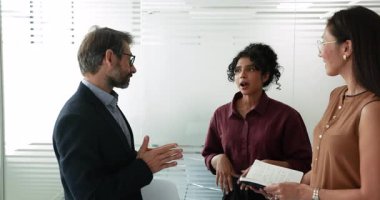 Çeşitli profesyonel takım üyeleri, verileri gözden geçirdikten ya da iş toplantılarını ya da sunumlarını tamamladıktan sonra görüşlerini paylaşıyor, geri bildirim paylaşıyor ya da sonraki adımları planlıyor. İletişim