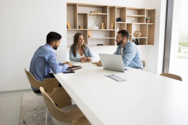 Yeni bir strateji geliştiriyorum. Üç farklı etnik çeşitlilikte profesyonelden oluşan ekip, atölye semineri için konferans masasında bir araya gelerek beyin fırtınası çözümlerini görüşmek üzere iş toplantısında birlikte çalışıyorlar. Boşluğu kopyala