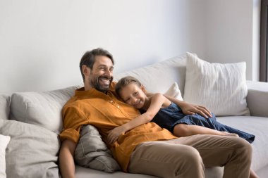 İnsanın içini ısıtan bir aile anı. Sevgi dolu küçük kız sevgili babasıyla yumuşak bir kanepede kucaklaşır. Hafta sonu evde huzur içinde dinlenir, babasıyla tanışır. Sonra da kavga üstüne kavga ederek zaman geçirir.