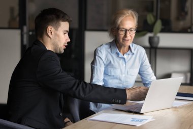 Genç işadamı CEO 'su online projeyi orta yaşlı güzel ofis bayan yöneticisine ya da müşterisine anlatıyor, iki meslektaşı bilgisayar ekranına bakıyor, finans ve strateji planları yapıyor.