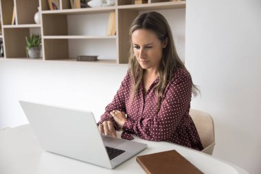 Teknoloji ve bağlantı. Gündelik orta yaşlı kadın girişimci tipleri rahat ev bilgisayarlarında e-posta arama bilgileri yazıyorlar online kaynaklarda serbest proje üzerinde çalışıyorlar araştırma yapıyorlar.