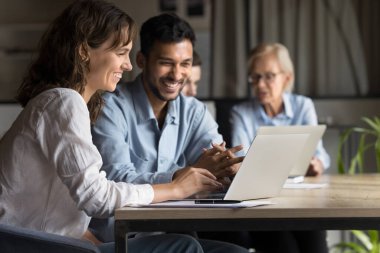 İki mutlu profesyonel yönetici dizüstü bilgisayarla çalışıyor, iş kadını ve iş kadını bilgisayar kullanıyor, çevrimiçi dijital projeyi tartışıyor, şirket toplantısında etkili bir işbirliği içinde eğleniyor.