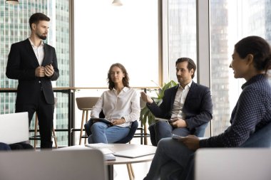 Grup projesi. Çeşitli genç iş adamları şirket çalışanları koç antrenör takım lideriyle birlikte modern şehir ofisinde beyin fırtınası eğitiminde buluştu.