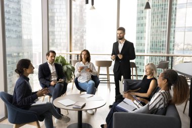 İş görüşmesi. Çeşitli iş arkadaşları ve takım lideri, panoramik pencerelerle modern ofiste toplanıyor. Beyin fırtınası geliştirme projesi başlatılıyor. Satış stratejilerini tartışıyor, atölyede planlar hazırlıyorlar.