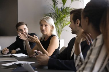 Uzman danışmanlığı. Ekip brifinginde konuşan kıdemli yetişkin iş kadını CEO patron, çeşitli çalışanların genç meslektaşlarıyla iş ortaklığı deneyimi paylaşması fikrini açıkladı.