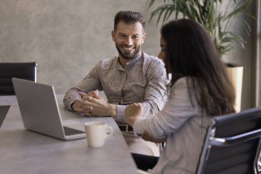 İki meslektaş dost canlısı ve rahat bir sohbete giriştiler. Masada dizüstü bilgisayar ve kahve ile oturdular, tartışmalara katıldılar, işle ilgili meseleleri çözdüler, güldüler, ofiste konuşmaktan zevk aldılar.