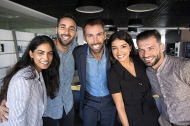 Beş tane çok ırklı genç ve olgun iş adamı poz veriyor, sarılıyor, sıraya giriyor, kameraya bakıyor, gülüyor, mutlu oluyor, ortak başarının tadını çıkarıyor, başarılar elde ediyor. Takım ruhu, işbirliği, birlik