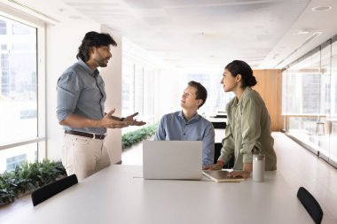 Takım arkadaşları dinleyin Hintli orta yaşlı patron yeni bilgiler sunuyor, ortak proje güncellemeleri, işle ilgili tartışmalar, ortak görev üzerinde işbirliği, beyin fırtınası, takım çalışmasına dahil olma