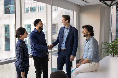 Gülen iş adamlarından oluşan bir grup toplantı odasında duruyor, iki işadamı el sıkışıyor, anlaşma jestleri yapıyor, ortaklık yapıyor ya da başarılı müzakerelerin tamamlanmasını sağlıyorlar. Güven, iş adabı