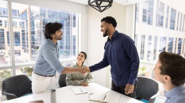 Pozitif Hintli ve Afrikalı iş ortakları görüşmelere konferans odasında başlıyorlar. İki işadamı el sıkışıyor, saygı gösteriyor, anlaşmayı imzalıyor, anlaşmayı sonuçlandırıyor,