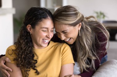 Şefkatli bir an. Mutlu bekar anne portresi gülümseyen ergen kızın omuzlarını kucaklıyor. Sevilen yetişkin çocuğa başını eğiyor. Nazik kahkahalarla gülüyor ve alınlarına kapalı gözlerle dokunuyorlar.