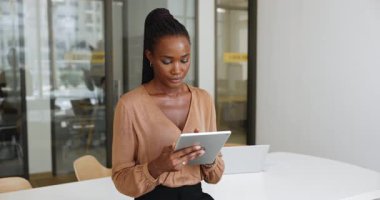 Modern teknoloji, kurumsal yazılım, çevrimiçi hizmet, iş başvurusu, sadece ofiste dijital tablete yazma, internette gezinme gibi şeylerle meşgul olan genç Afrikalı Amerikalı iş kadını.