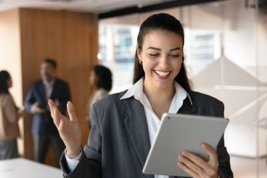 Tablete bakarken coşkuyla hareket eden mutlu iş kadını, dijital iletişimden keyif alıyor, başarılı proje güncellemesi hakkında olumlu haberler alıyor, iyi geri bildirim alıyor, satış artışı, promosyon