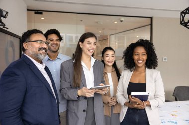 Modern konferans odasında durup gülen, satış büyümesinden, takım çalışması sonuçlarından, profesyonel başarılardan ve başarılardan memnuniyet duyan çok uluslu personel üyeleri. Liderlik