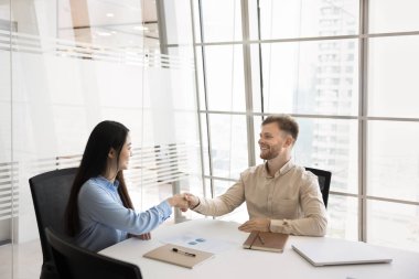 Çok ırklı iş adamları toplantı salonundaki resmi toplantı için el sıkışıyorlar. Asyalı ve Kafkasyalı ortaklar tartışmayı bitirdiler, ofiste görüşmeler, karşılıklı saygıyı ifade eden el sıkışmalar. Anlaştık.