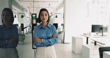 Kendine güvenen genç İspanyol profesyonel kadın ofis yönetim kurulunun yönetim kurulunda duruyor. El ele tutuşup güven jesti yapıyor ve mutlu oluyor. Şirket portresi