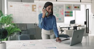 Mutlu genç İspanyol proje yöneticisi kadın büyük tablette cep telefonuyla konuşuyor pazarlama finansal raporlarıyla, dizüstü bilgisayarla yazı yazıyor, sadece iş iletişimi için aletler kullanıyor.