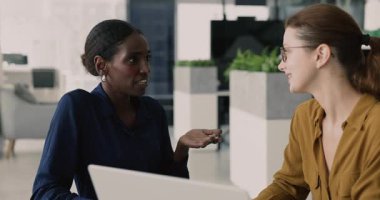 Kendine güvenen Afrikalı Amerikalı profesyonel danışman kadın meslektaşı, çalışanı, işyerinde stajyeri, dizüstü bilgisayarını gösteren, online proje hakkında danışmanlık yapan,