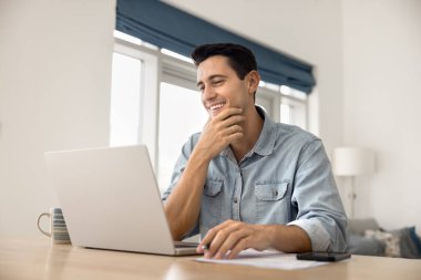 Üretken bir zihniyet. Gülümseyen başarılı milenyum işadamı uzaktan kumandalı olarak çalışan elektronik evrak işleriyle uğraşan dahili ofisteki defteri kullanarak yaratıcı fikir çözümünü düşünün.