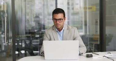 Masada oturan, dizüstü bilgisayarda yazan, verileri analiz eden veya mesleki görev üzerinde çalışan, iş e-postalarını okuyan ve cevaplayan, modern işyerinde teklif veya iş planı yazan odaklı işadamı