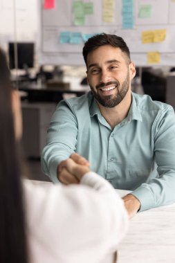 Genç İspanyol işadamı kadın müşteriyle el sıkışıyor toplantı odasında, dikey çekimde oturuyor. İK yöneticisi başvuru sahibini karşılarken ya da iş görüşmesini başarılı bir şekilde bitirirken. Kiralama, iş