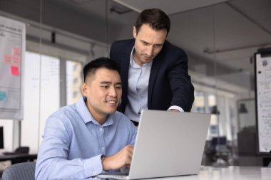 İki takım arkadaşı dizüstü bilgisayar, iş teklifi veya sözleşmesini kullanarak çevrimiçi projede işbirliği yapıyor, proje yönetim araçlarını kullanarak bir sonraki adımları planlıyorlar. Modern teknolojiyi kullanarak akıl hocalığı, takım çalışması