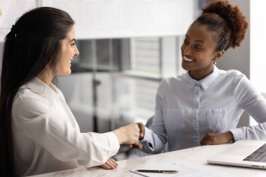 Afrikalı ve İspanyol profesyonel iş kadınları, girişimciler masada oturuyor, el sıkışarak birbirlerine saygı göstererek, anlaşma yaparak, müzakereleri sonuçlandırarak resmi toplantıya başlıyorlar. Anlaşma, satın alma.