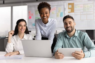 Takım çalışması, görev tamamlama, strateji oluşturma, üretken ve etkili iş akışından memnun olmak için ofis içinde kameraya poz veren üç farklı meslektaşın portresi