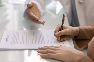 Ticari klinikteki kadın hasta, sağlık hizmeti için sözleşme imzalıyor, destek veriyor, onay veriyor, tıbbi prosedür için anlaşma yapıyor, sigorta yaptırmak için imza atıyor.
