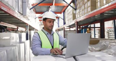 Genç 35 'likler, iyi organize edilmiş bir depoda çalışan İspanyol' a odaklandılar. Dizüstü bilgisayar üzerinde çalışırken koruyucu kask ve yelek giyip envanter belgelerini gözden geçirdiler. Lojistik, envanter yönetimi, tedarik zinciri